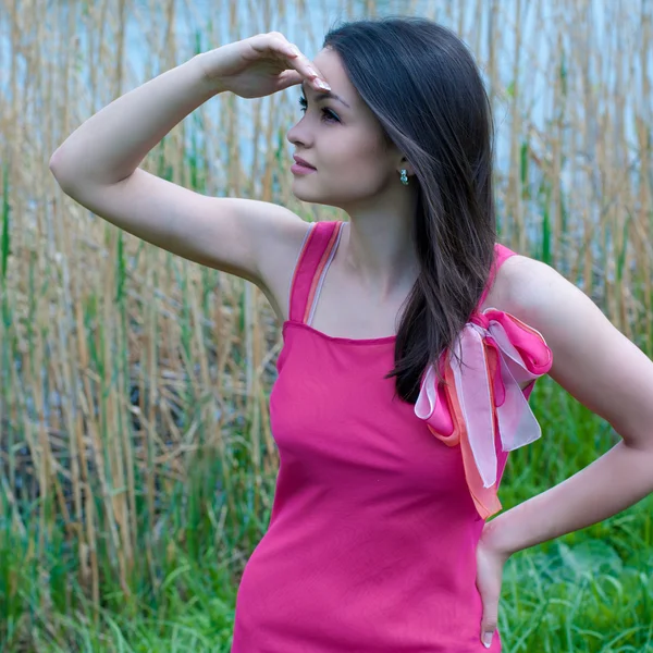 Молодая красивая женщина в розовом платье — стоковое фото