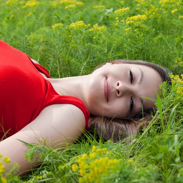 Jovem mulher bonita deitada na grama verde — Fotografia de Stock