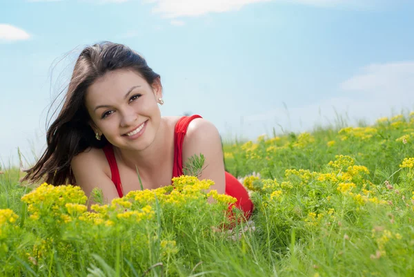 Jonge mooie vrouw liggend op groen gras — Stockfoto