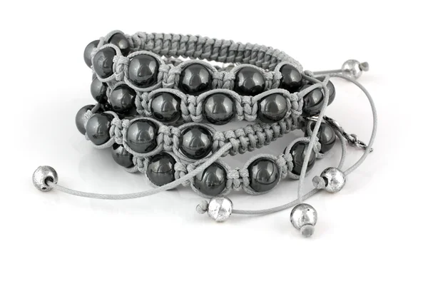 Armbanden met zwarte parels en op wit — Stockfoto