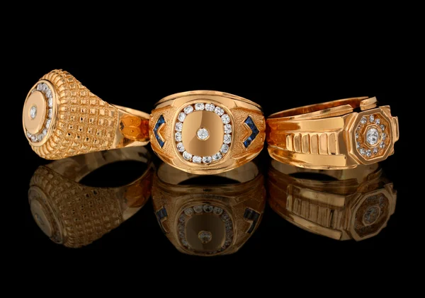 Gouden ringen met diamanten op zwart — Stockfoto