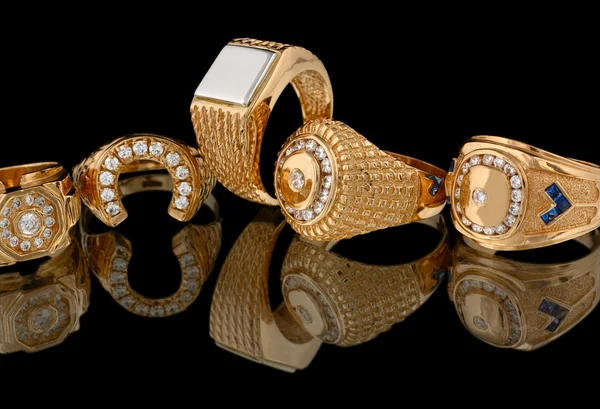 Anéis dourados com diamantes isolados em preto — Fotografia de Stock