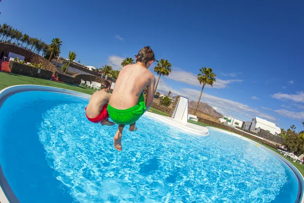 Boy jumping in the blue pool — Stock Photo, Image