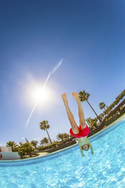 Oğlan mavi havuza atlama — Stok fotoğraf