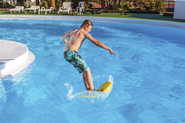 Pojken hoppar i blå poolen — Stockfoto