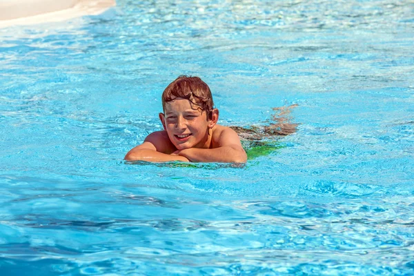 Мальчик в бассейне расслабляется — стоковое фото