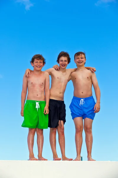 Drei Freunde in Schwimmbekleidung halten zusammen — Stockfoto