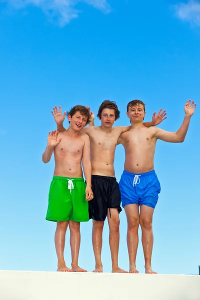 Tre amici in swimmware bastone insieme — Foto Stock