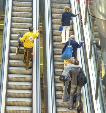 Passenger in terminal 4 on a moving staircase clipart