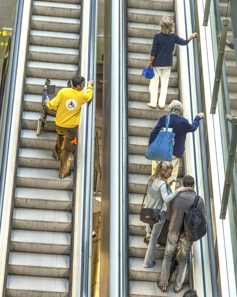 Pasajero en la terminal 4 en una escalera móvil —  Fotos de Stock