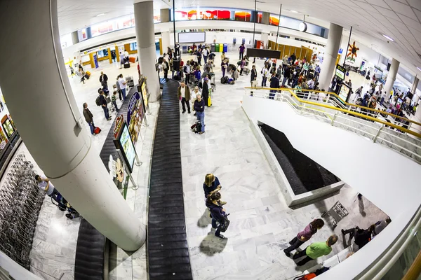 Toeristen wachten op hun bagage op de luchthaven — Stockfoto