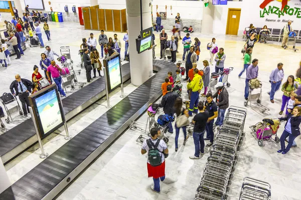 Touristen warten am Flughafen auf ihr Gepäck — Stockfoto