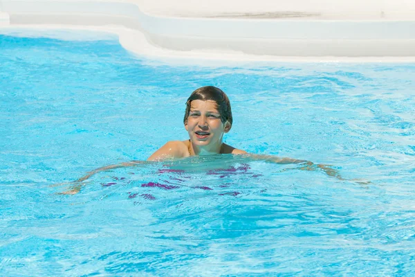 Мальчик плавает в бассейне — стоковое фото