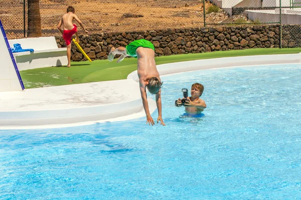 Jovem fotógrafo tira fotos na piscina — Fotografia de Stock