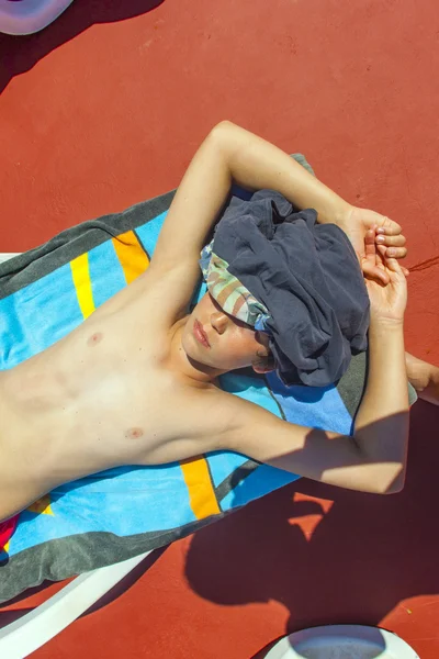 Aranyos fiú pihentető a medence mellett — Stock Fotó