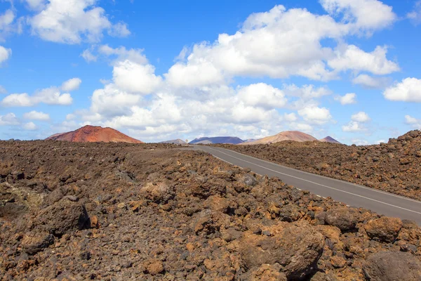 Estrada através de rochas de lava e montanhas vulcânicas. Los Hervideros . — Fotografia de Stock