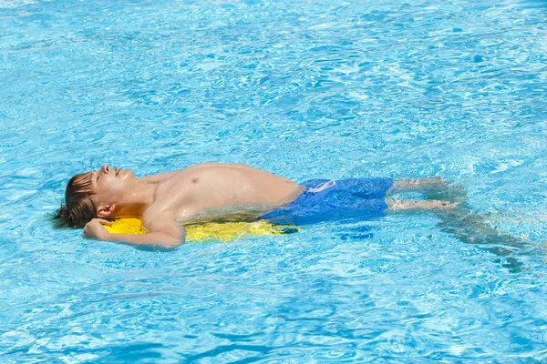 Jongen zwemmen in het zwembad — Stockfoto