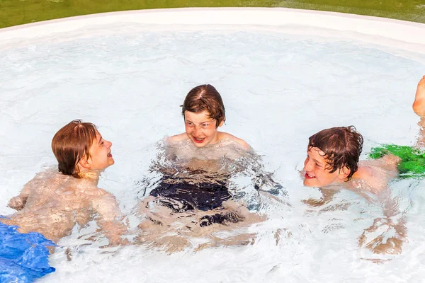 Tres amigos se divierten en la piscina — Foto de Stock