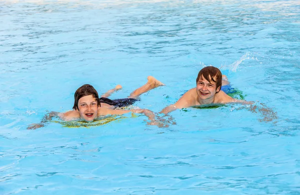 Dois amigos nadando na piscina — Fotografia de Stock