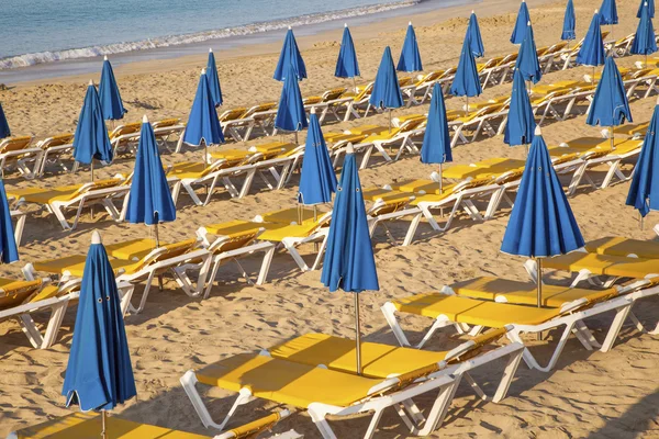 Песчаный пляж по утрам с пляжными шезлонгами и зонтиками — стоковое фото