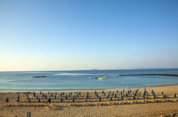 Pantai Sandy di pagi hari dengan tempat tidur pantai dan payung — Stok Foto
