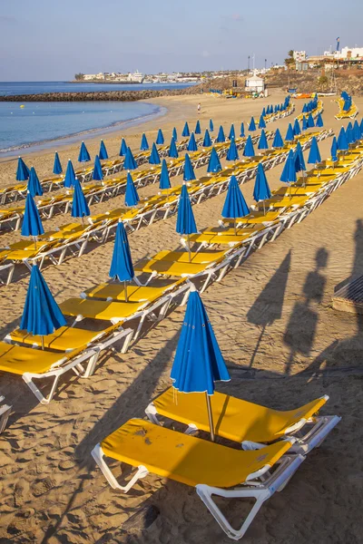 Sandy beach in the morning with beach beds and umbrella — Stock Photo, Image