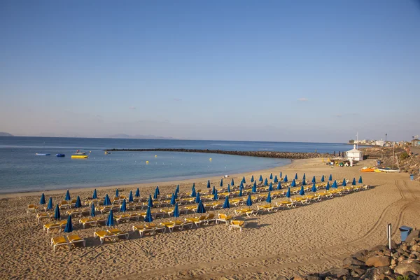Pantai Sandy di pagi hari dengan tempat tidur pantai dan payung — Stok Foto