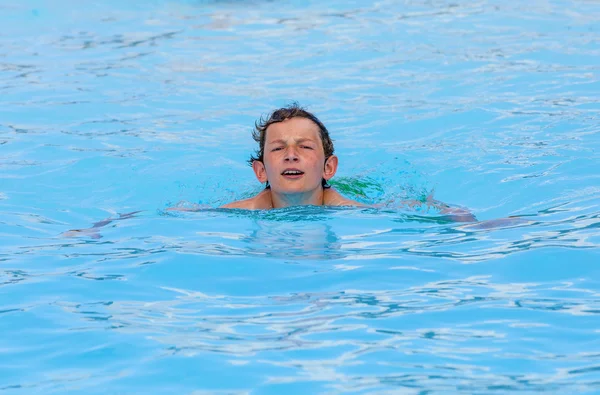 Glücklicher Junge schwimmt im Pool — Stockfoto