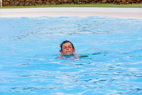 Счастливый мальчик плавает в бассейне — стоковое фото