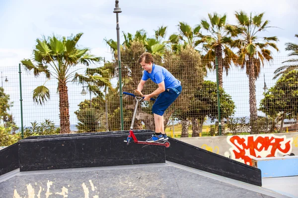 Junge fährt mit Roller im Skatepark — Stockfoto