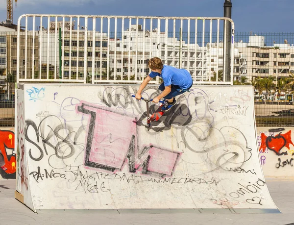 Menino monta sua scooter no parque de skate — Fotografia de Stock