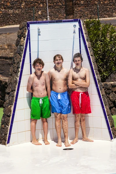 Chlapci unter fond sprchapojkar har roligt unter pool dusch — Stock fotografie