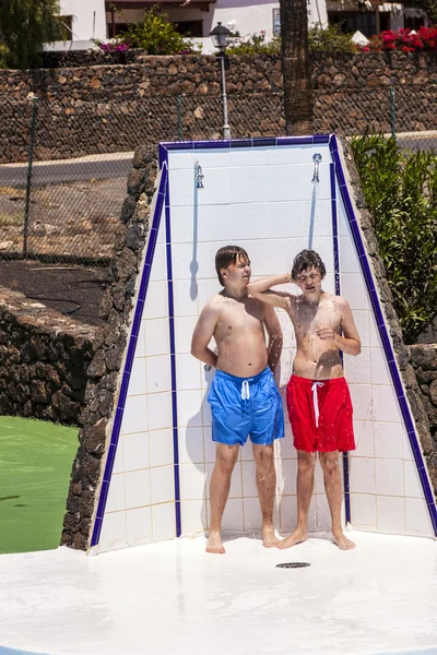 Les garçons s'amusent sous la douche de la piscine — Photo