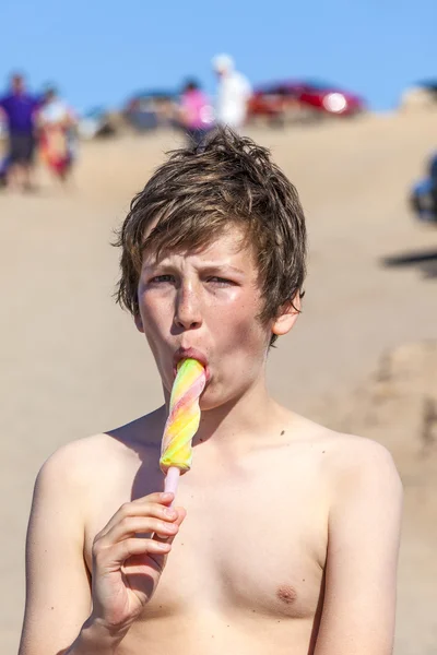 Letní prázdniny: roztomilý teen jíst zmrzlinu na pláži — Stock fotografie