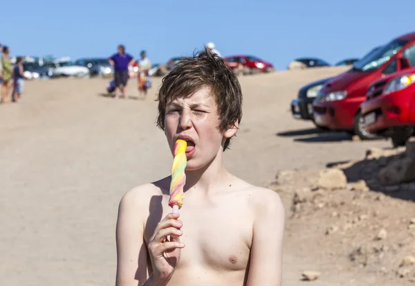 Літня відпустка: милий підліток їсть айсберг на пляжі — стокове фото