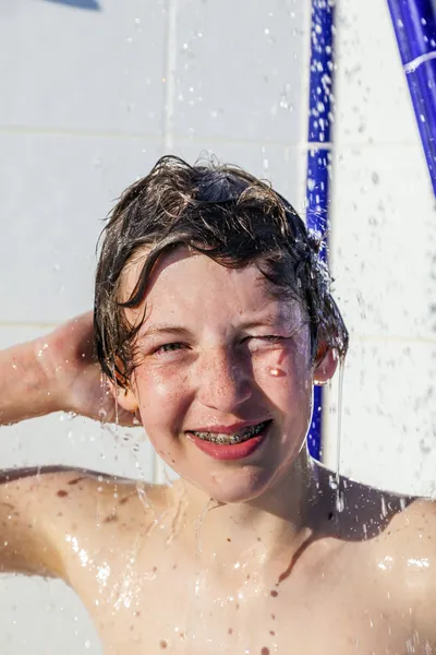 Хлопчик розважається в душі басейну — стокове фото