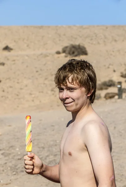 Wakacje: ładny nastolatek jeść lody na plaży — Zdjęcie stockowe