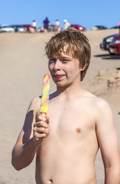 Летние каникулы: милый подросток ест мороженое на пляже — стоковое фото
