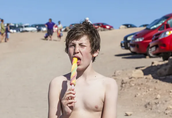 Letní prázdniny: roztomilý teen jíst zmrzlinu na pláži — Stock fotografie