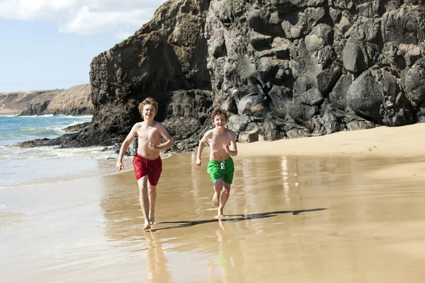 Chlapci jsou spuštěny na pláži — Stock fotografie