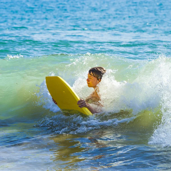 Хлопчик розважається серфінгом у хвилях — стокове фото