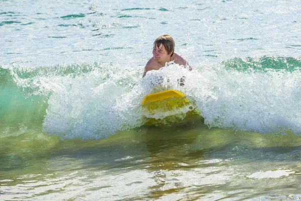 Хлопчик розважається серфінгом у хвилях — стокове фото