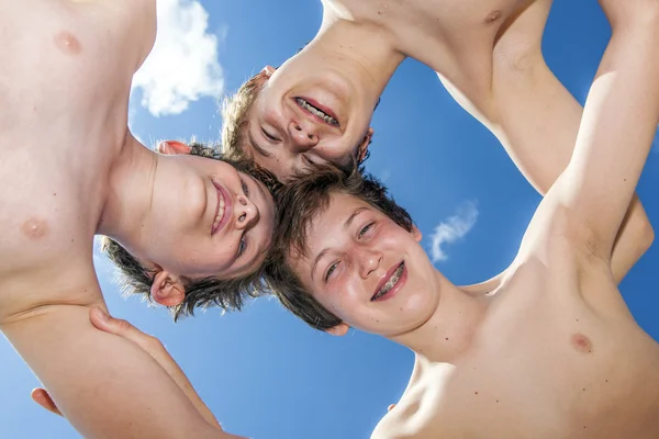 Vista a basso angolo di ragazzi felici in piedi insieme in un cerchio agai — Foto Stock