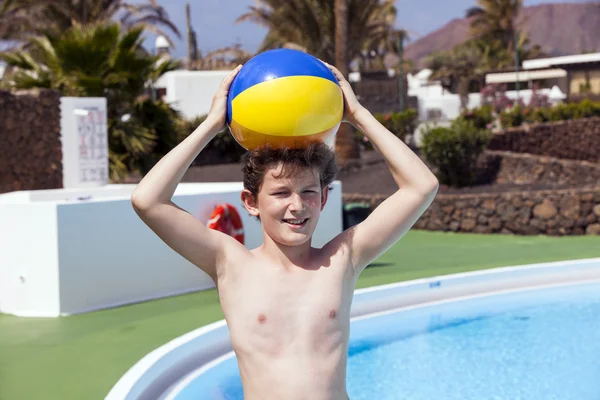 Cute boy carrying a plastic ball on his head — Stock Photo, Image