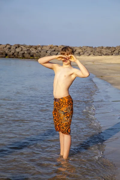 Chłopiec znajduje się plaża w porannym słońcu — Zdjęcie stockowe