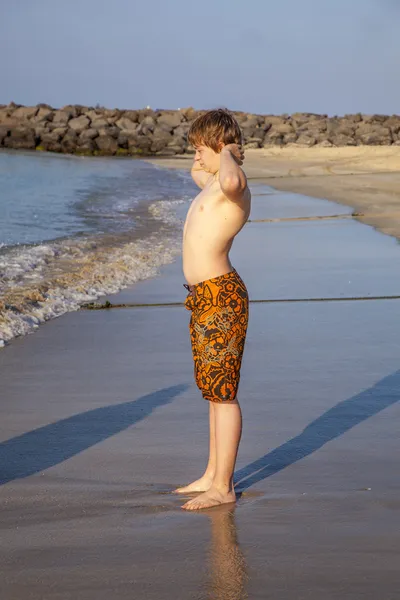 Мальчик наслаждается пляжем под утренним солнцем — стоковое фото