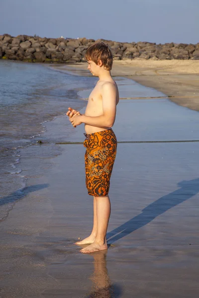 Мальчик наслаждается пляжем под утренним солнцем — стоковое фото