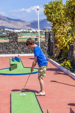 Oğlan mini golf oynamayı seviyor.