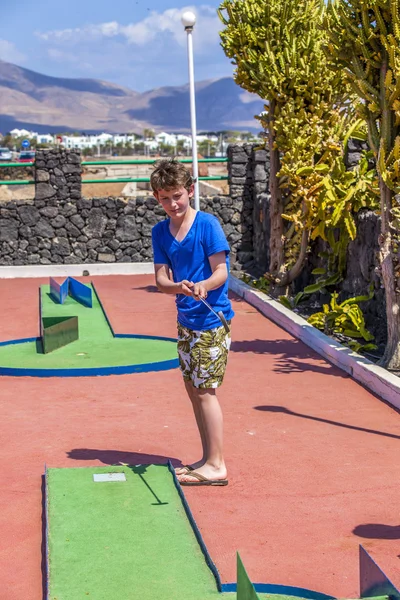 Мальчик любит играть в мини-гольф — стоковое фото