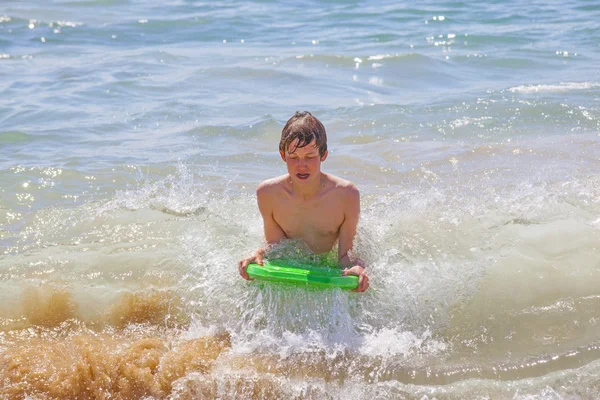 Roztomilý chlapec surfování ve vlnách — Stock fotografie